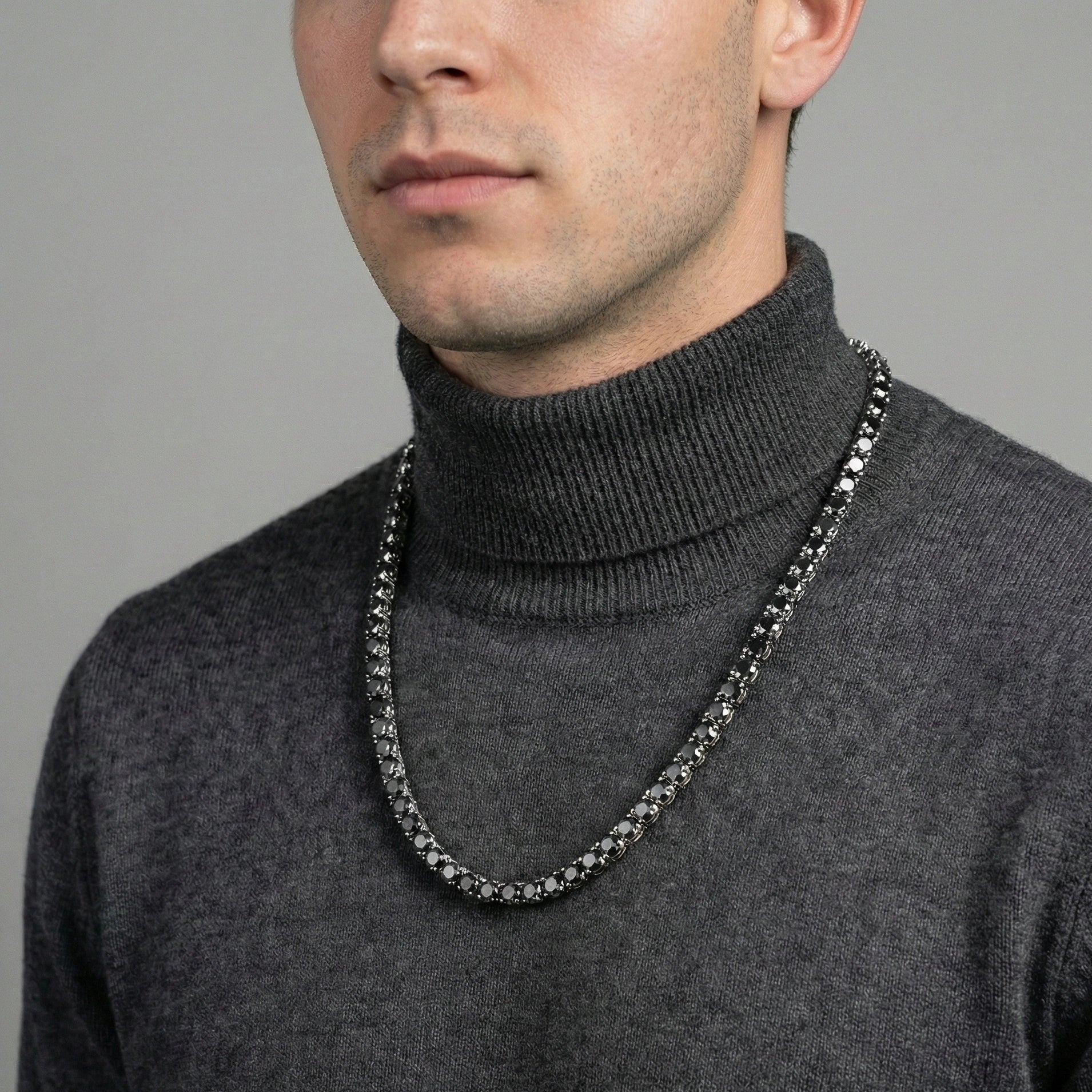 Man styling 4mm black moissanite tennis necklace with white gold plating with gray turtleneck for sophisticated modern look - Sensitive Stones