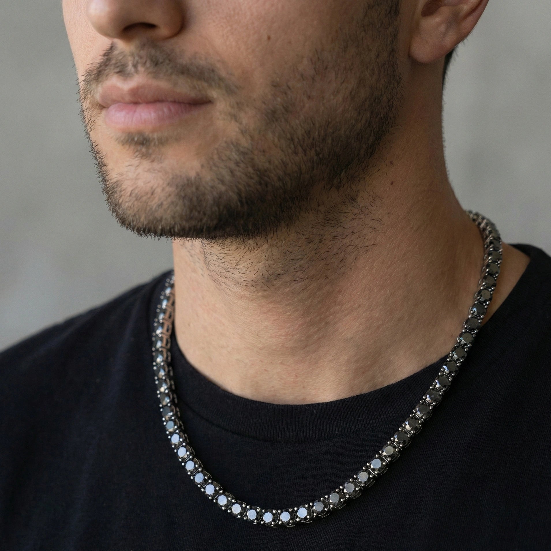 Man wearing 4mm black moissanite tennis necklace in white gold plating with black t-shirt showing unisex versatile design - Sensitive Stones