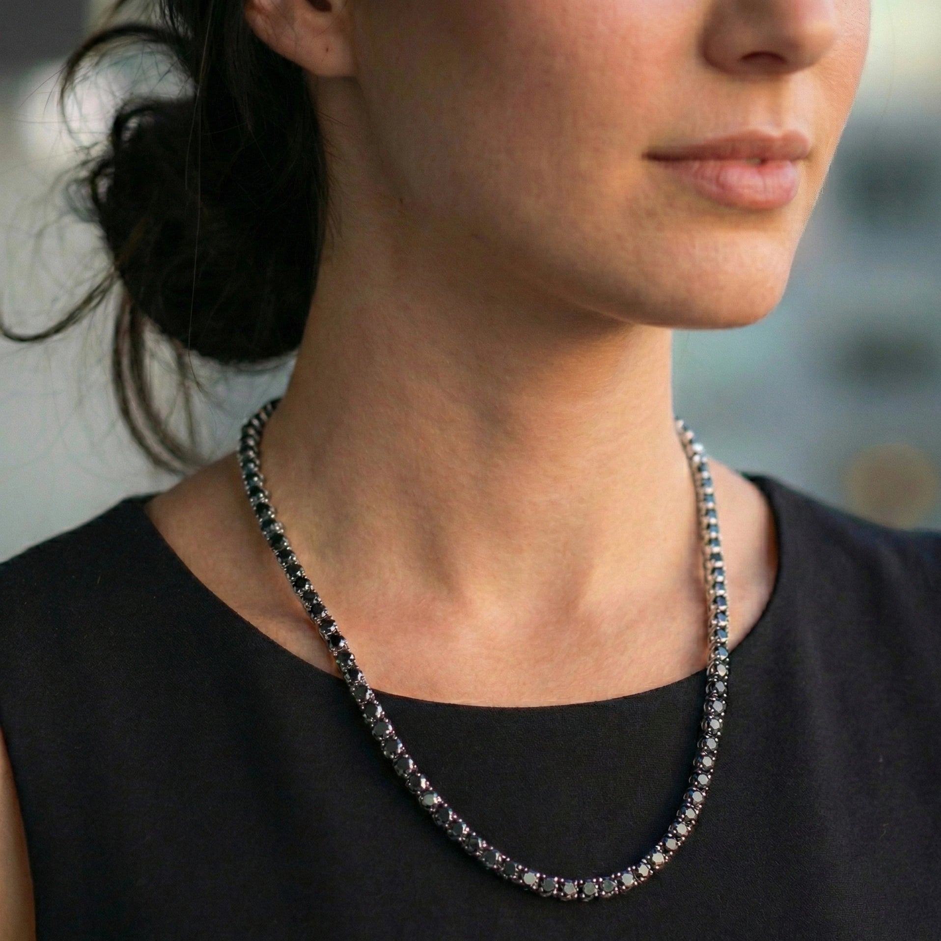 Woman wearing 4mm black moissanite tennis necklace with white gold plating with black top showing elegant everyday style - Sensitive Stones