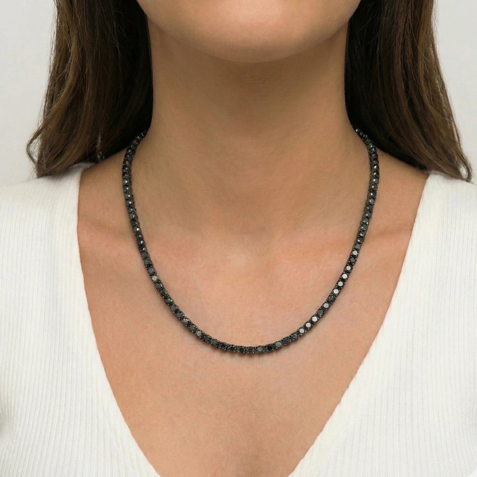 3mm black moissanite tennis necklace with black gold plating worn by woman in white top displaying delicate sparkle - Sensitive Stones