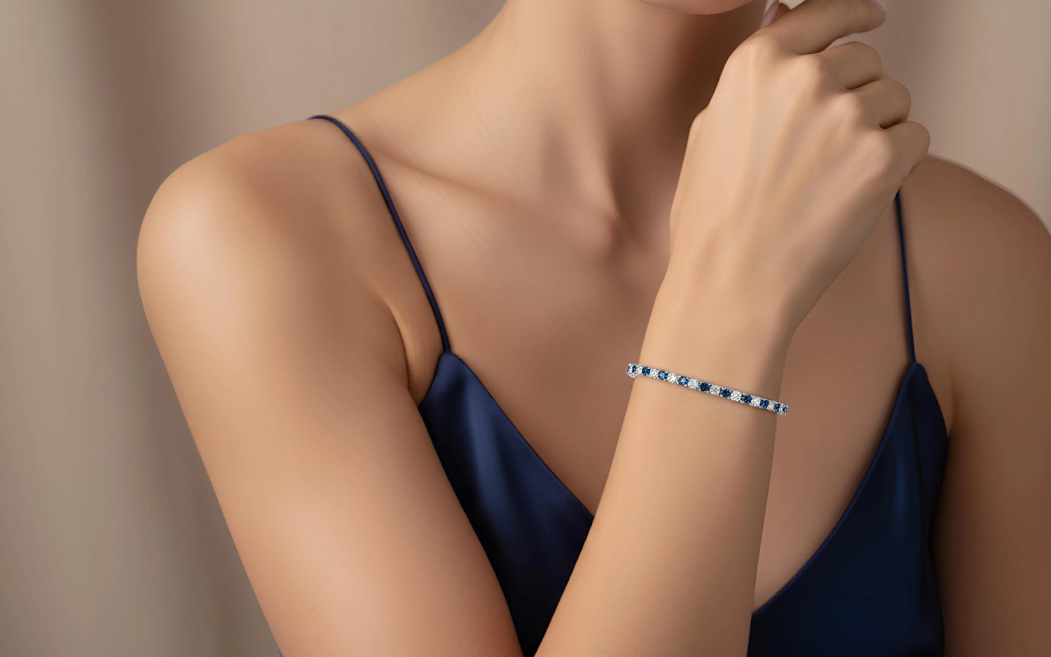 Blue and white moissanite tennis bracelet in sterling silver, elegantly worn with a navy satin dress — quiet luxury jewelry by Sensitive Stones