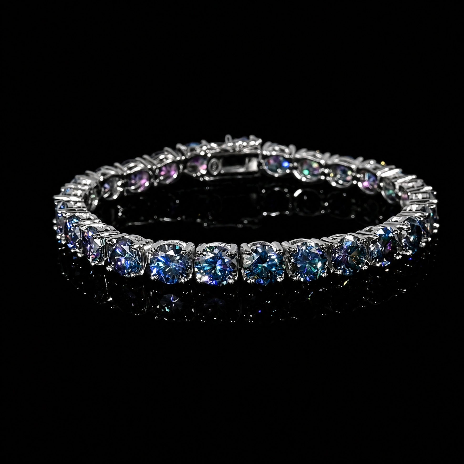 Full blue moissanite tennis bracelet, color-shifting round-cut stones in 925 sterling silver, box clasp, on a reflective black surface - Sensitive Stones