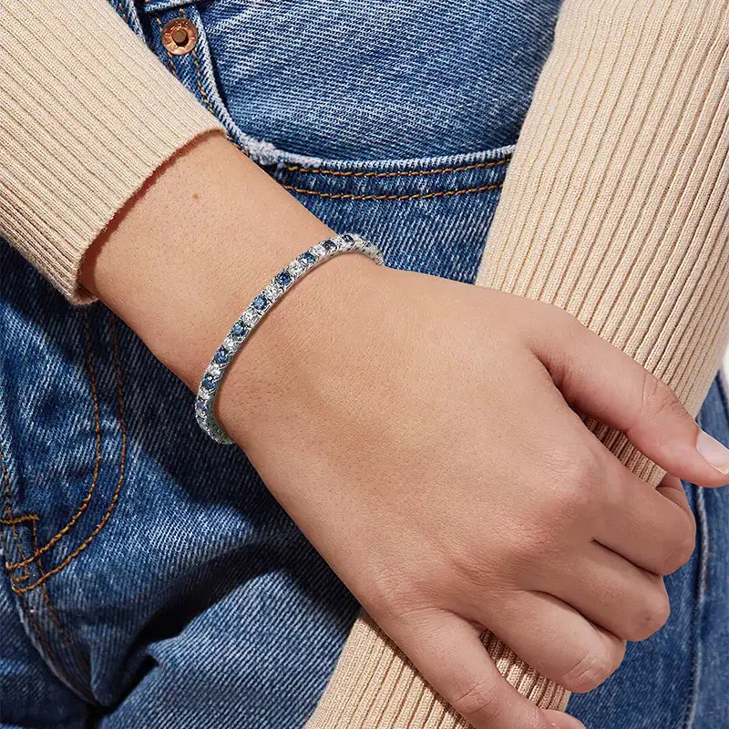 Blue and white moissanite tennis bracelet worn on wrist with beige knit sleeve, minimalist lifestyle photo – Sensitive Stones
