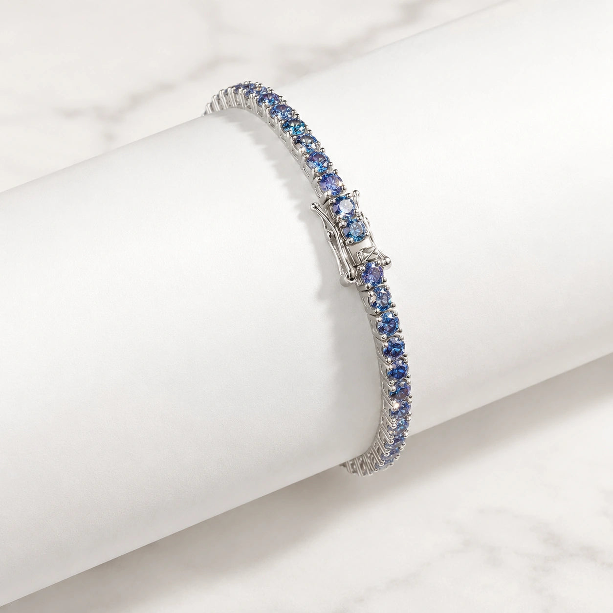 Close up view of clasp and stones on Blue Moissanite Tennis Bracelet in prong setting, crafted in sterling silver with 18K white gold finish - Sensitive Stones