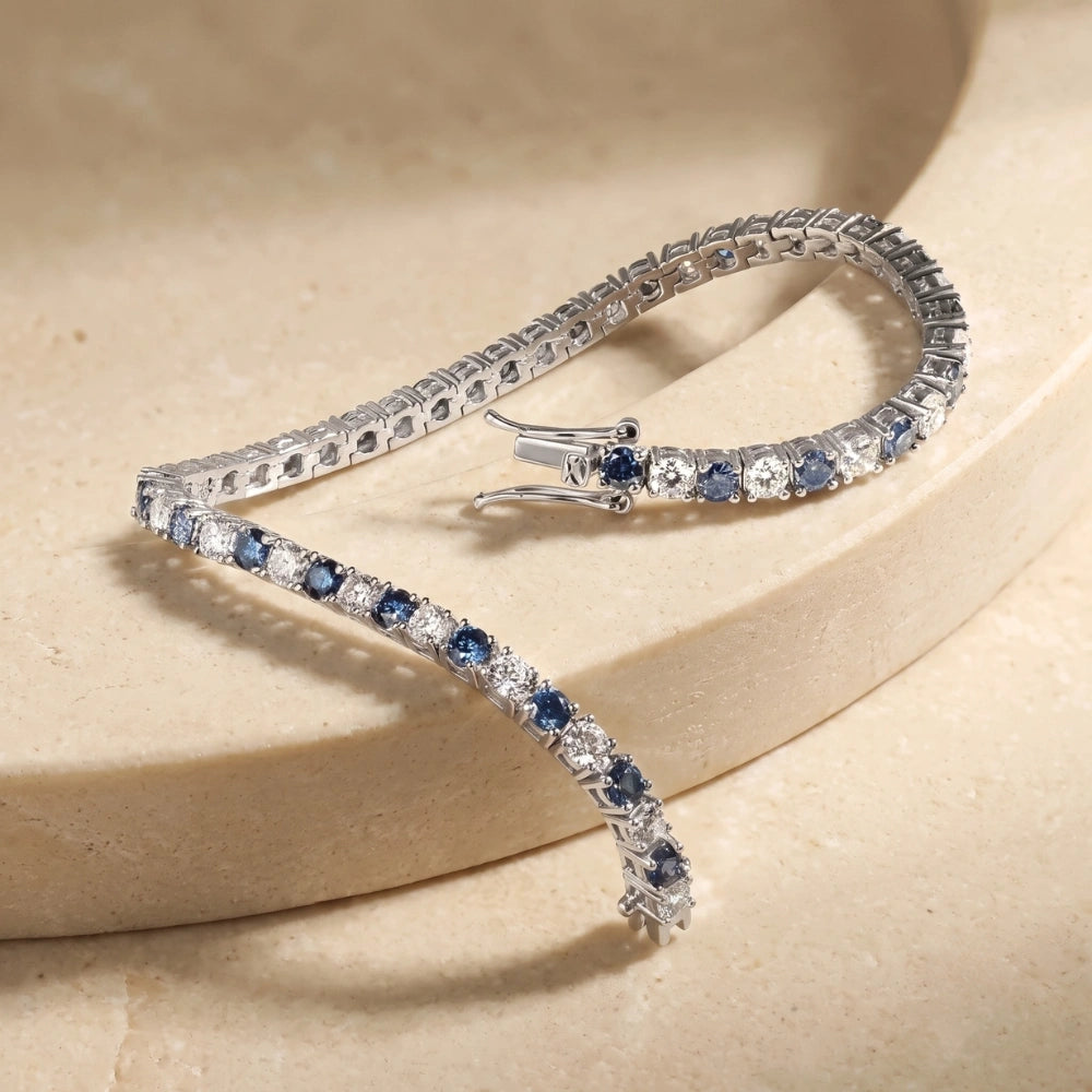 Blue and white moissanite tennis bracelet displayed on warm beige surface, elegant product detail view – Sensitive Stones