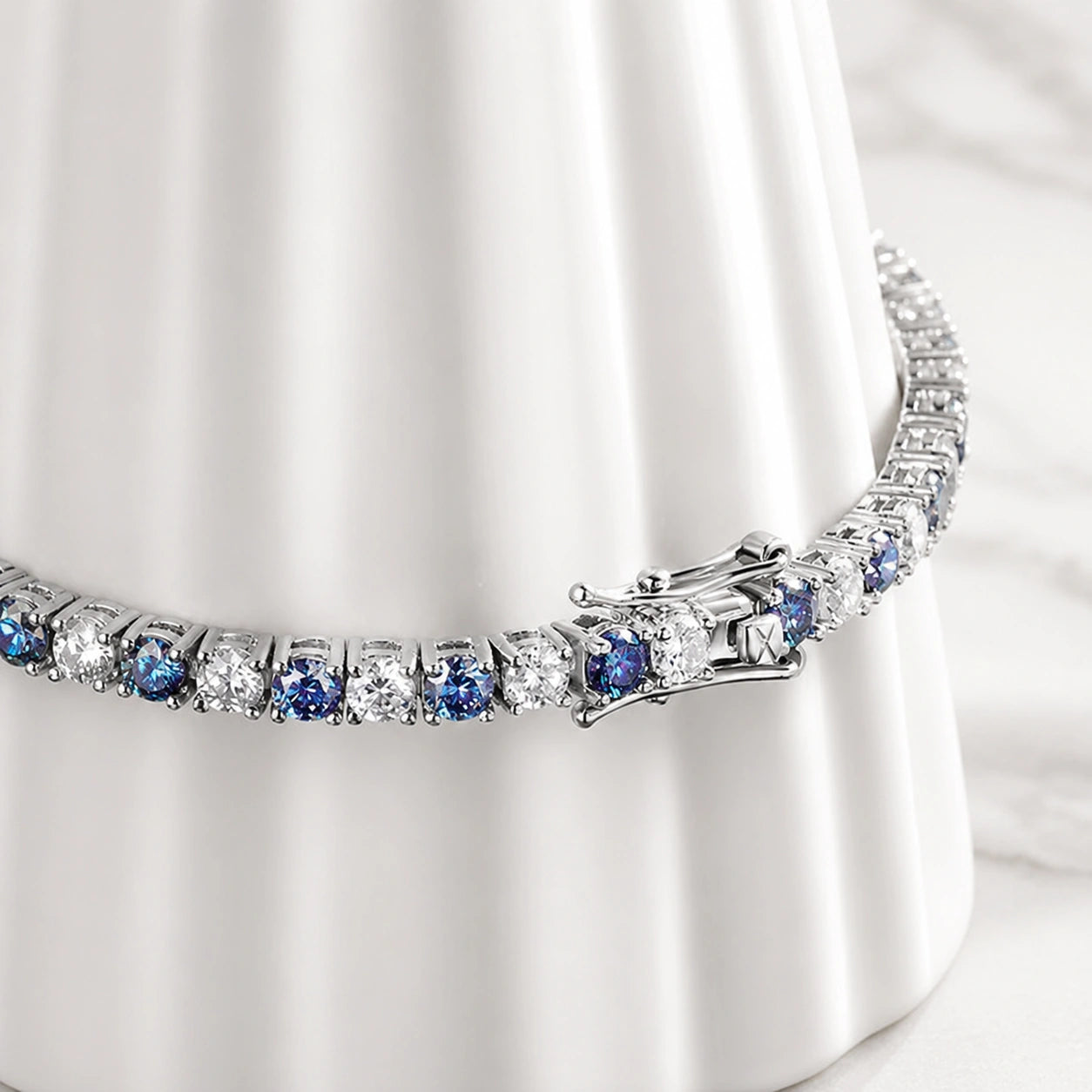 Detailed view of clasp and stones on Blue Moissanite Tennis Bracelet, featuring alternating blue and white moissanite gems in prong setting, crafted in sterling silver with 18K white gold finish - Sensitive Stones