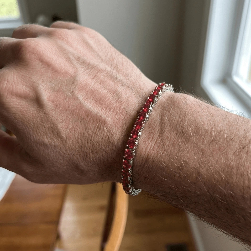 Close-up of a man's wrist wearing a 4mm red moissanite tennis bracelet in 925 silver and white gold plating - Sensitive Stones