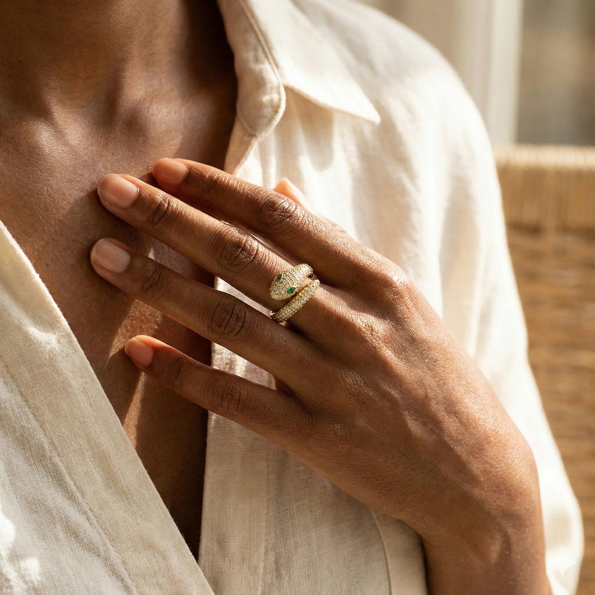 Close-up of a hand wearing moissanite snake ring in 18k gold finish with green gemstones, against a neutral background - Sensitive Stones