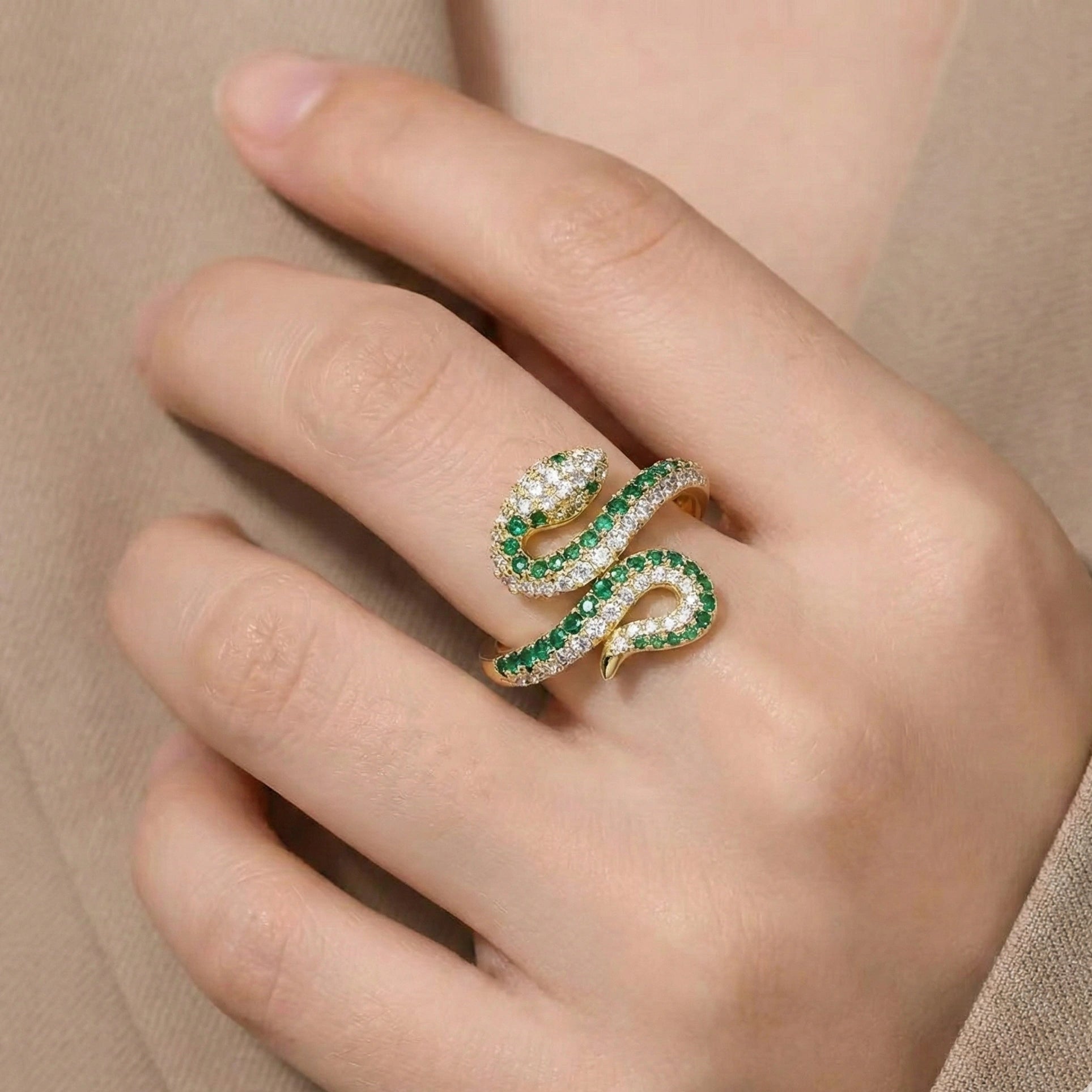 Woman wearing gold plated coiled moissanite snake ring with green gemstones - Sensitive Stones