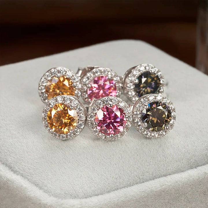 Colored moissanite halo stud earrings in golden yellow, pink and gray displayed in velvet jewelry box - Sensitive Stones