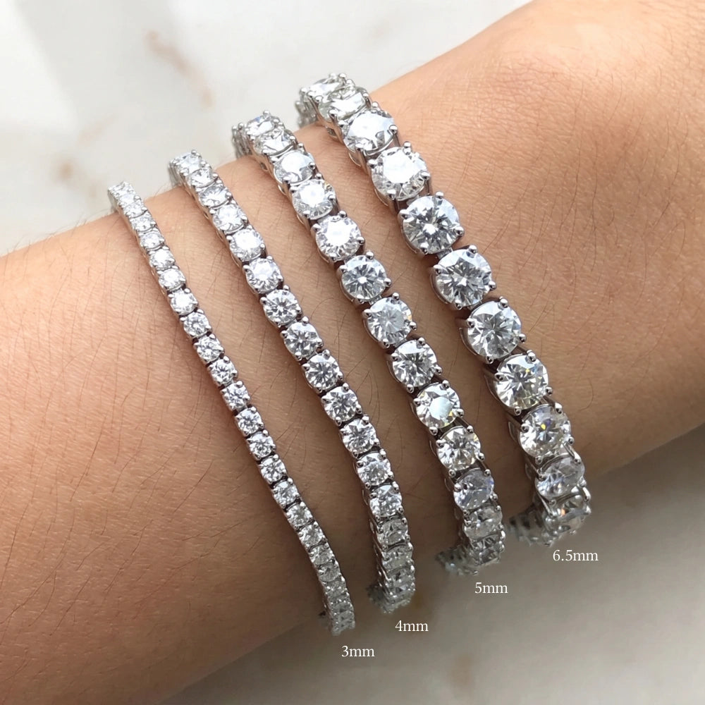 Four moissanite tennis bracelets with clear round-cut stones worn on a wrist, shown with size labels indicating 3mm, 4mm, 5mm, and 6.5mm - Sensitive Stones