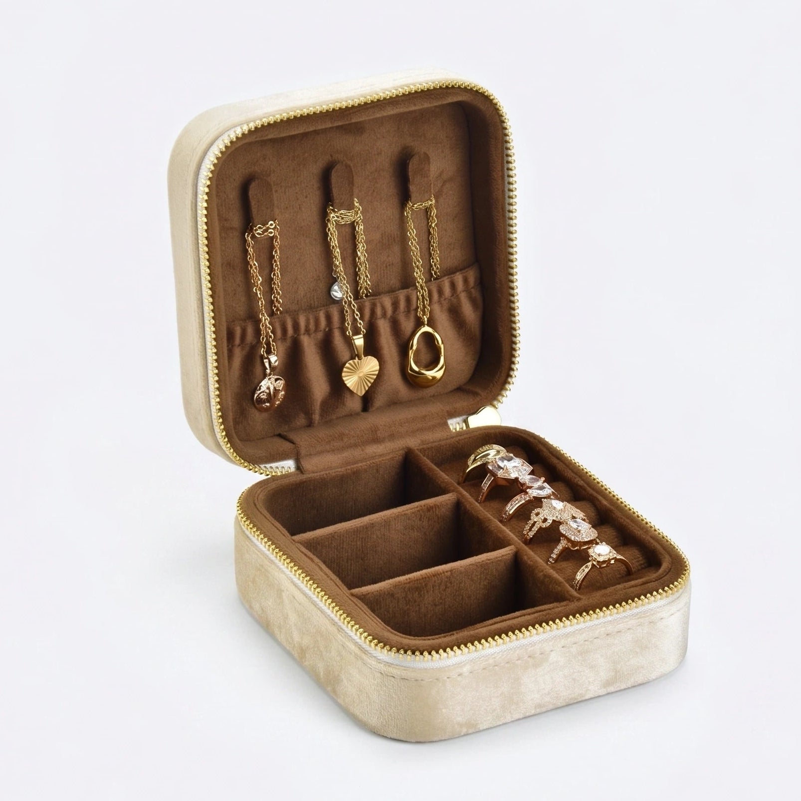 Cream velvet travel jewelry box open showing necklace hooks with gold pendants and rings organized inside - Sensitive Stones