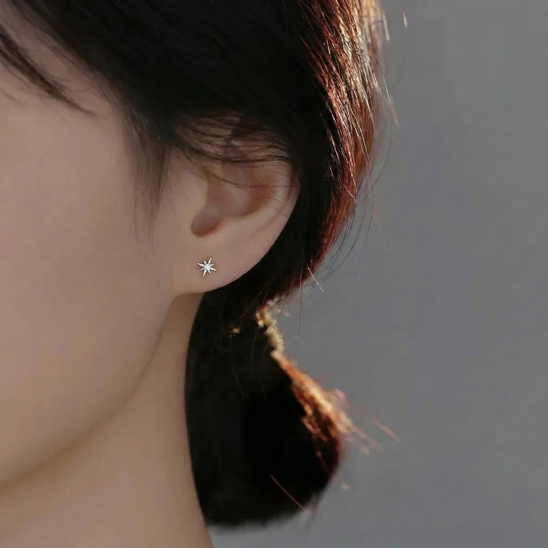 Close-up of a woman wearing a cubic zirconia star stud earring in 925 silver   - Sensitive Stones