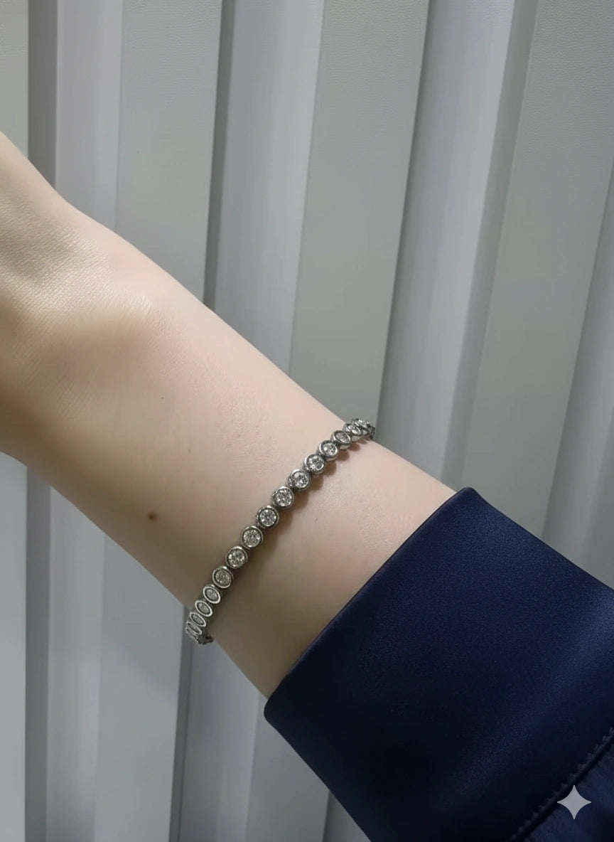 Dainty bezel moissanite tennis bracelet featuring 3mm round D color VVS1 stones in solid 925 sterling silver on wrist - Sensitive Stones