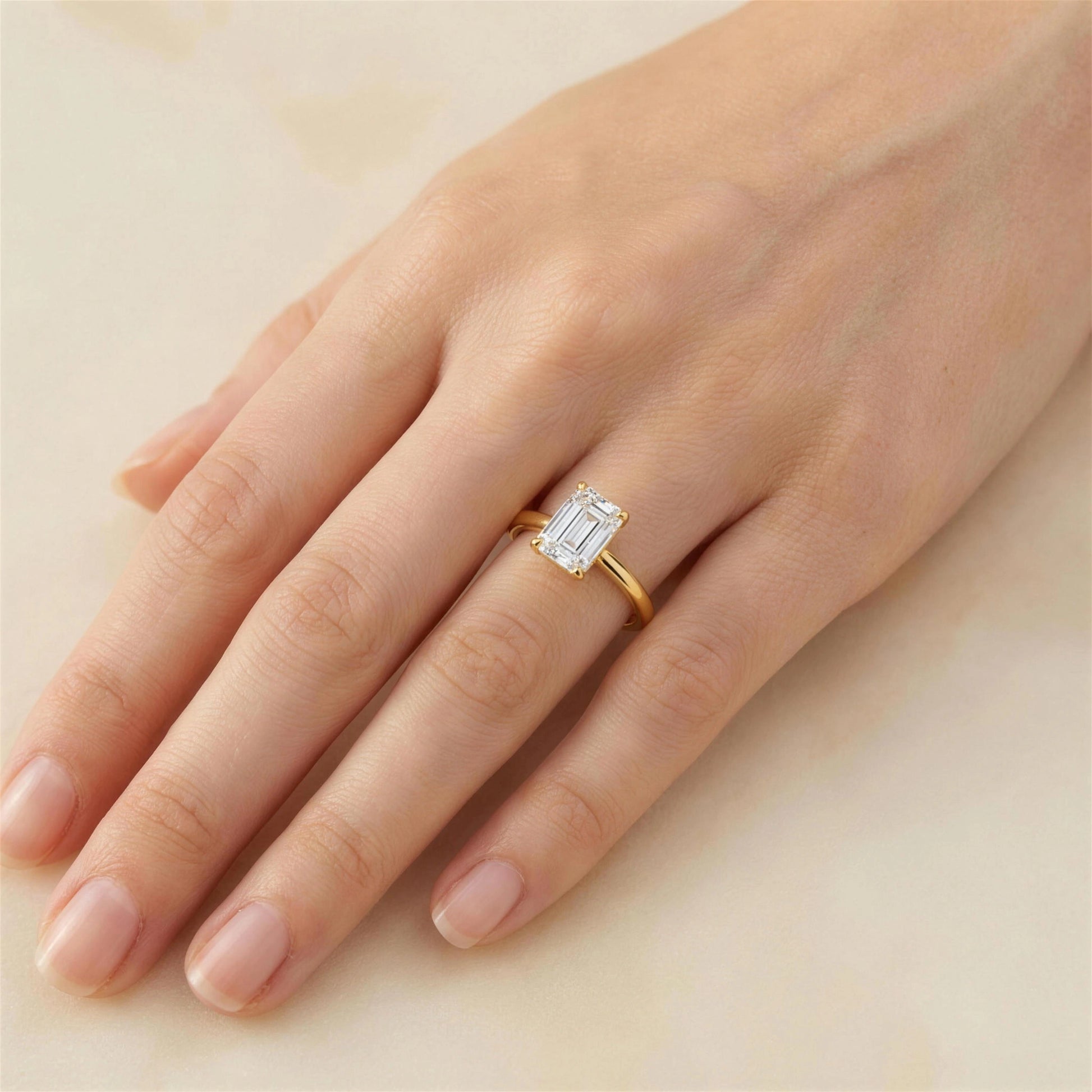 Woman wearing emerald cut moissanite engagement ring in 14K gold filled close up - Sensitive Stones