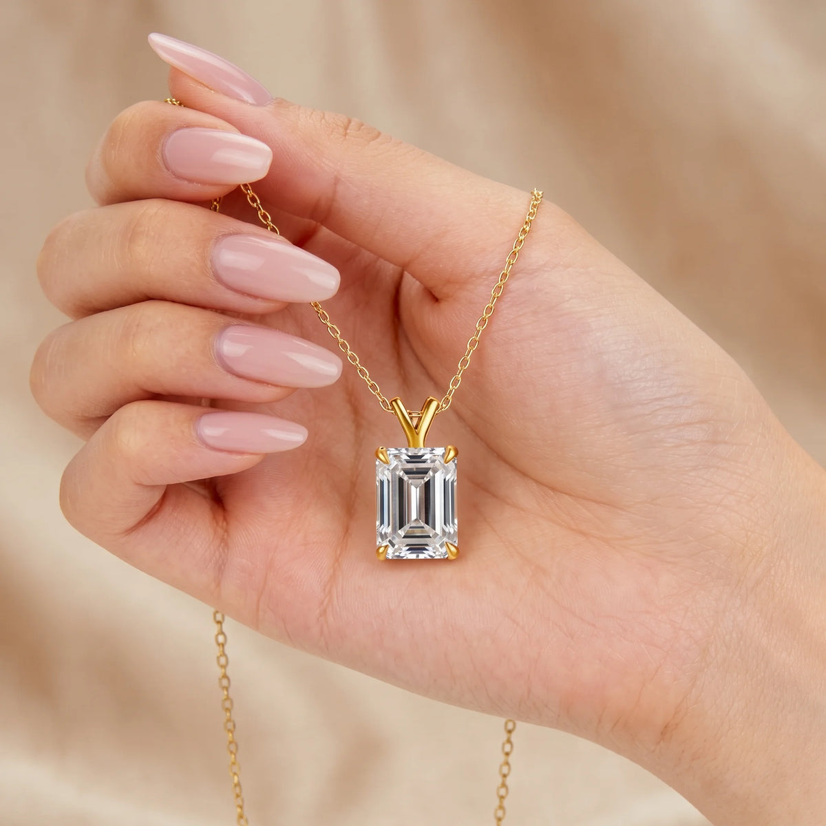 Emerald cut moissanite pendant necklace in 14K gold filled held in the hand to show its size - Sensitive Stones