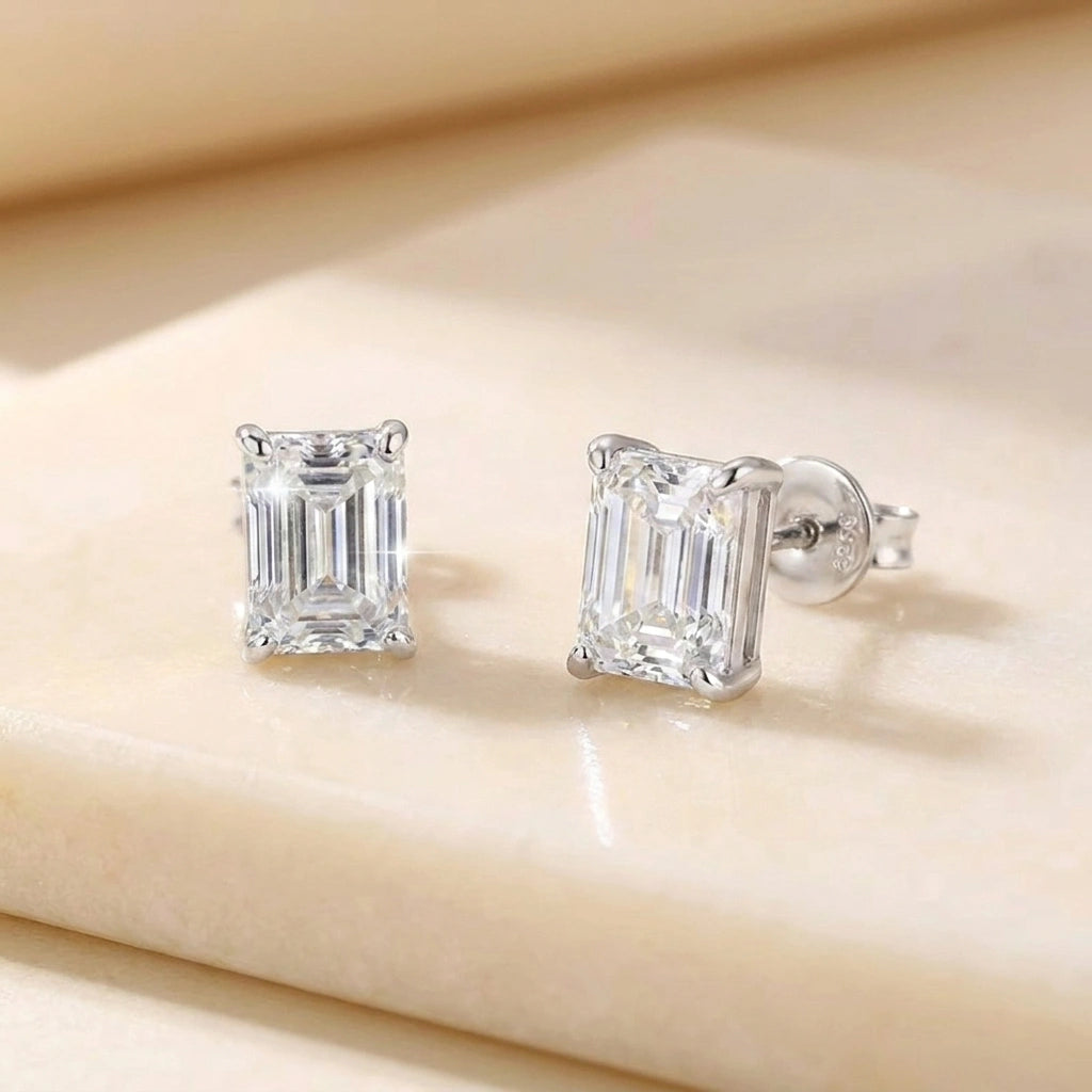 Emerald cut moissanite stud earrings in white gold, front and side view of the 4-prong basket setting - Sensitive Stones