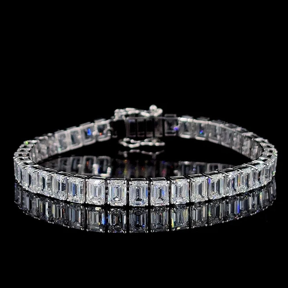 Emerald cut moissanite tennis bracelet, step-cut D VVS1 stones in 925 sterling silver, on a black reflective surface - Sensitive Stones