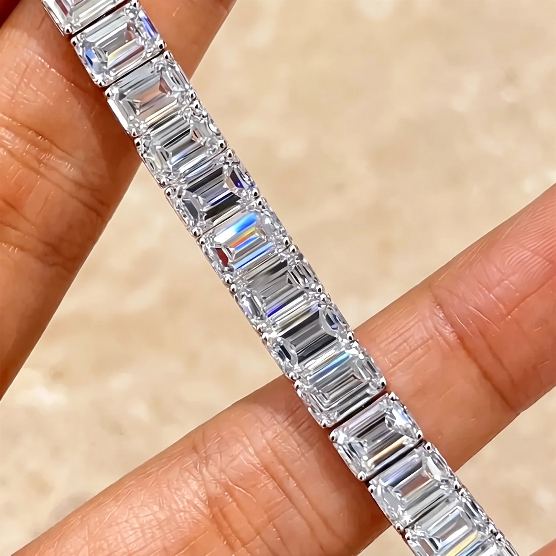 Close-up detail of emerald cut moissanite step-cut facets on a tennis bracelet in 18K white gold plated 925 sterling silver - Sensitive Stones
