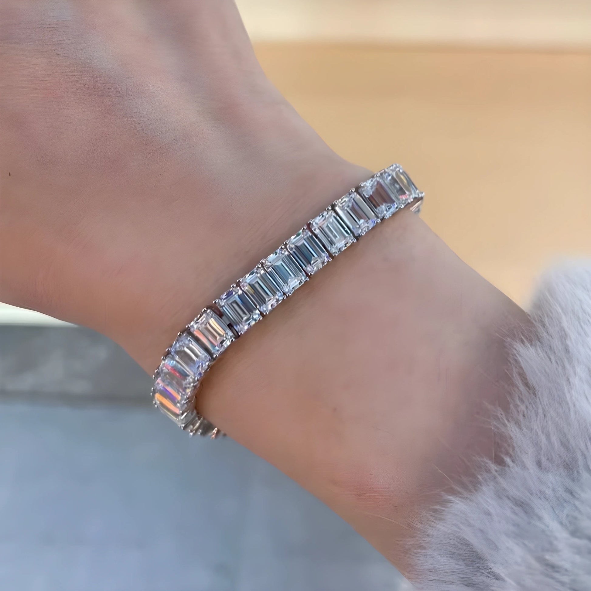 Woman wearing an emerald cut moissanite tennis bracelet, east-west set step-cut stones in 925 sterling silver - Sensitive Stones