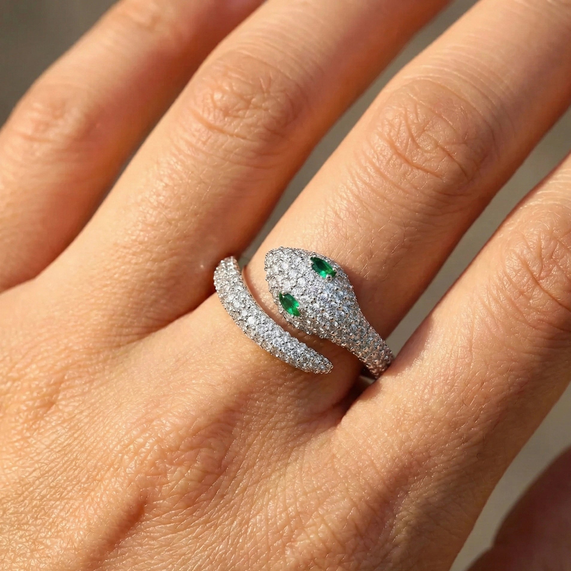 Close up of hand wearing emerald-eyed moissanite snake ring in 925 sterling silver with pavé moissanite stones and lab emerald eye - Sensitive Stones