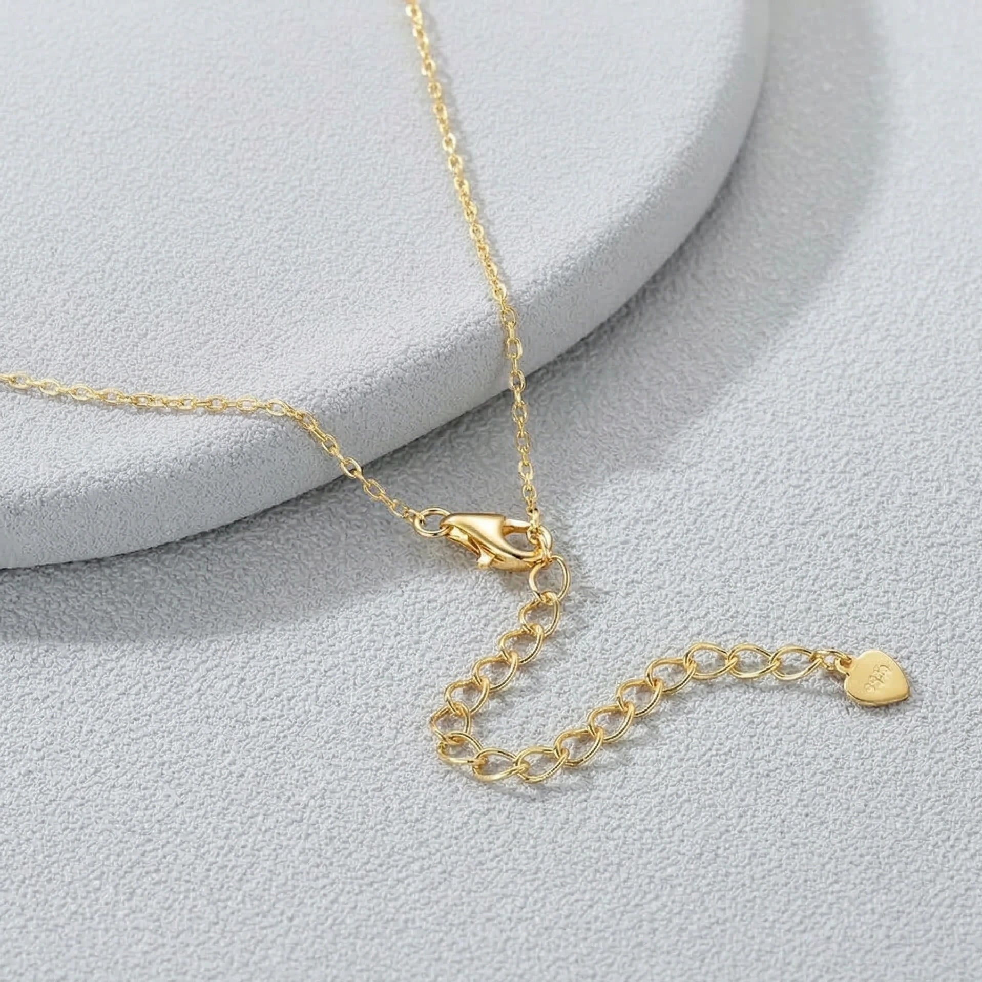 Close up of gold lobster clasp and extender chain on bezel moissanite necklace - Sensitive Stones