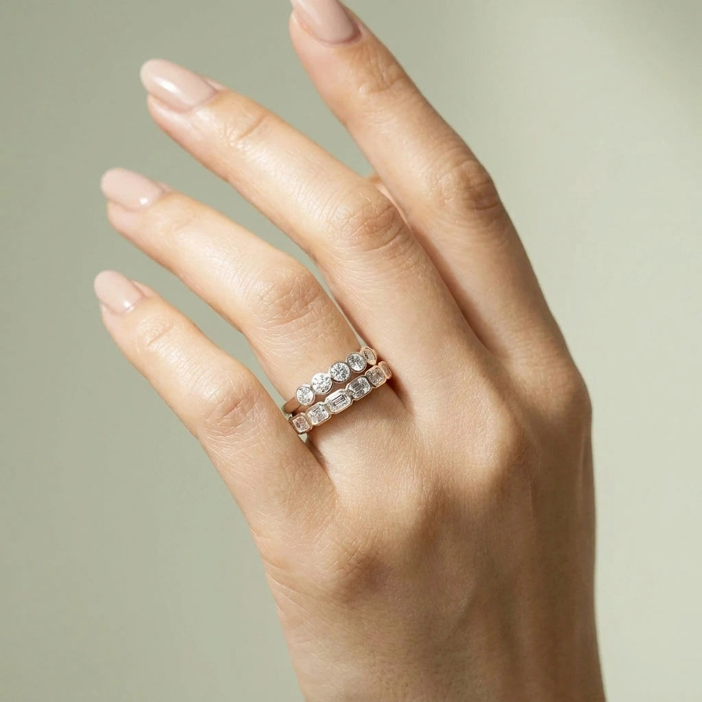 Hand wearing the five stone bezel moissanite ring stacked with an emerald cut bezel band - Sensitive Stones