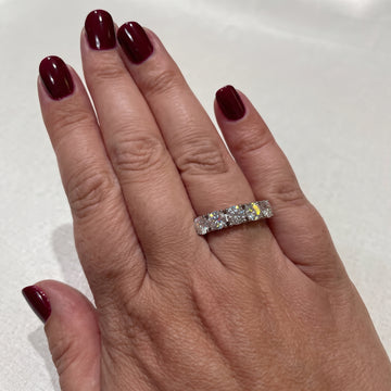 Hand with deep red nails wearing the 2.5ct five stone moissanite anniversary band in white gold - Sensitive Stones
