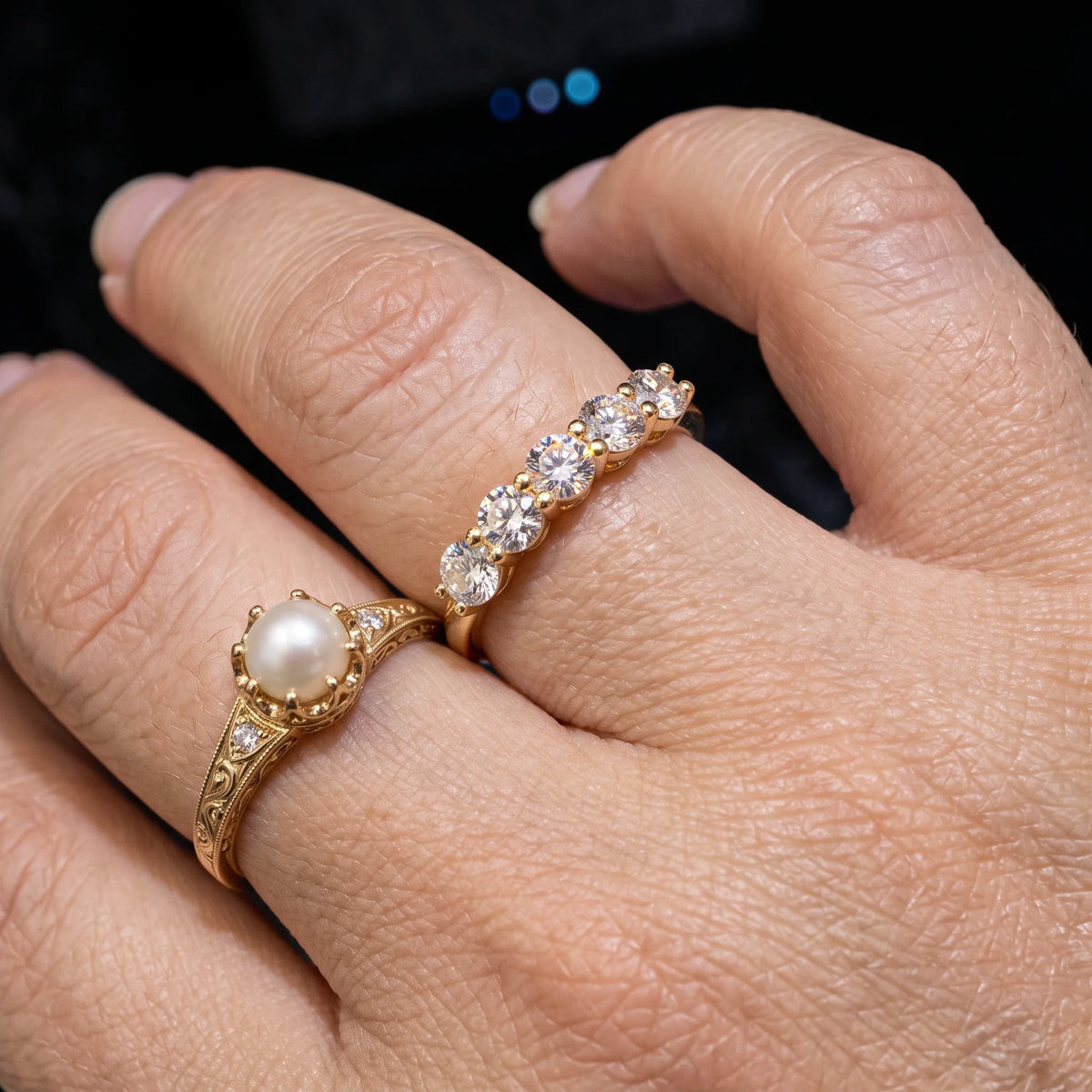 Five stone moissanite stackable ring in 14K gold filled worn stacked beside a pearl ring, showing the slim low band - Sensitive Stones