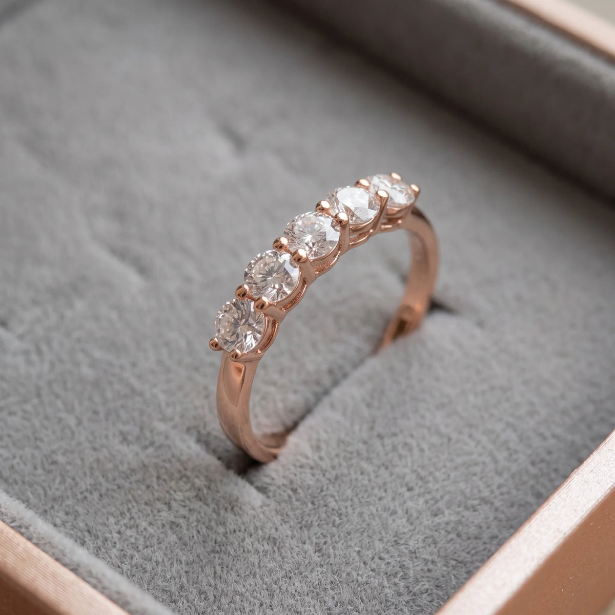 1ct five stone moissanite wedding band in rose gold finish standing in a grey velvet ring box - Sensitive Stones