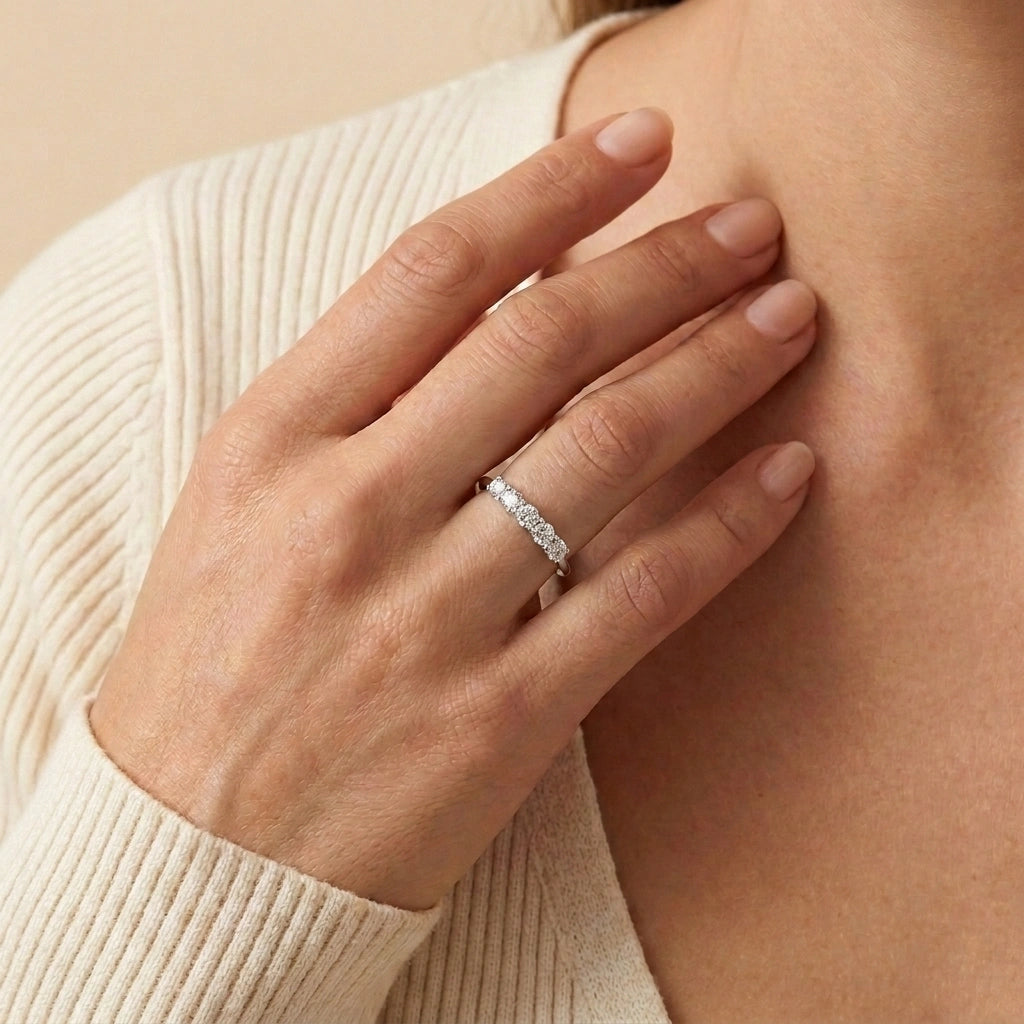 Woman in a cream knit wearing the five stone moissanite wedding band in white gold - Sensitive Stones