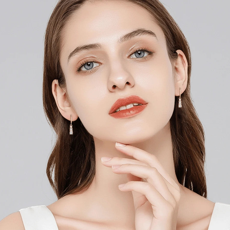 Front view of moissanite three-stone dangle earrings in gold finish worn by model - Sensitive Stones