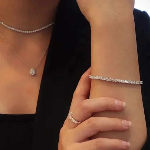 Styled look of moissanite tennis bracelet paired with matching ring and necklace for women.