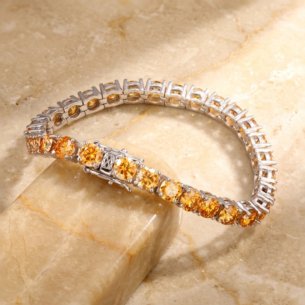 Golden yellow moissanite tennis bracelet in white gold plated sterling silver displayed on a marble surface - Sensitive Stones