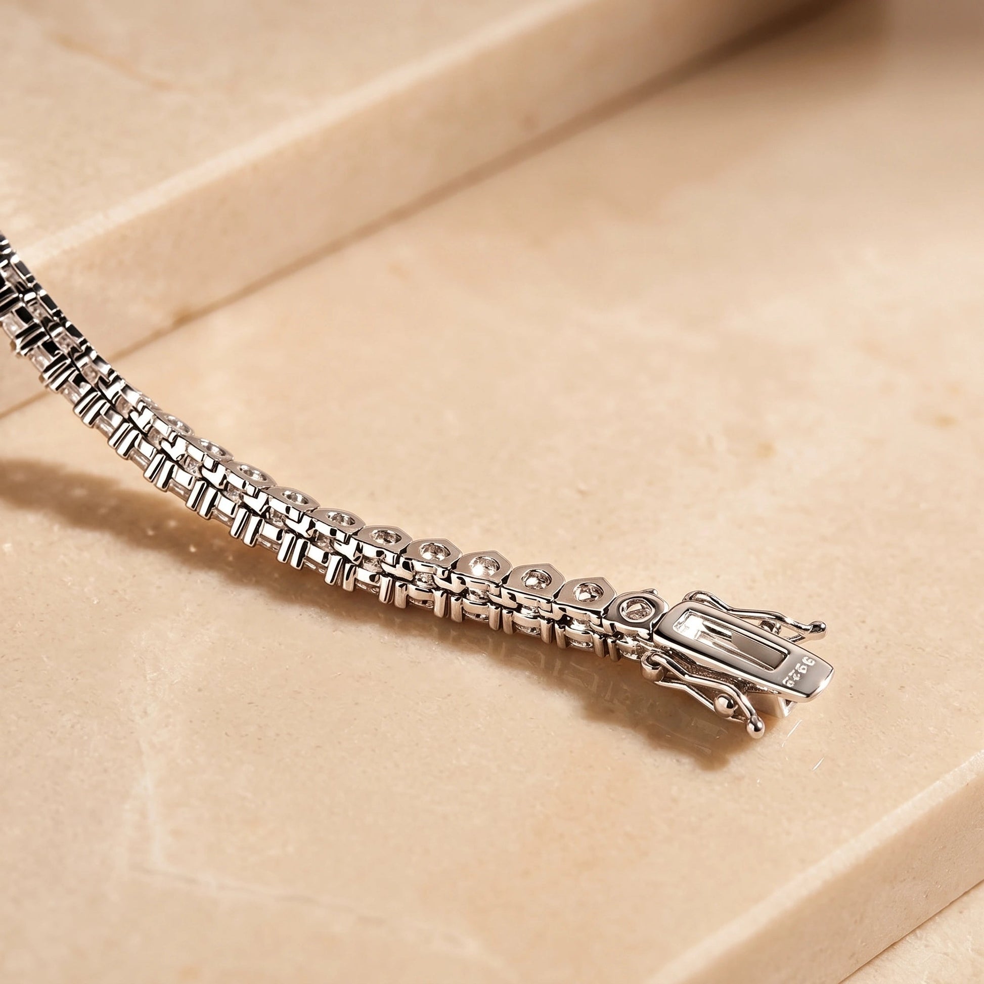 Underside of a graduated moissanite tennis necklace showing the box clasp and 925 sterling silver stamp