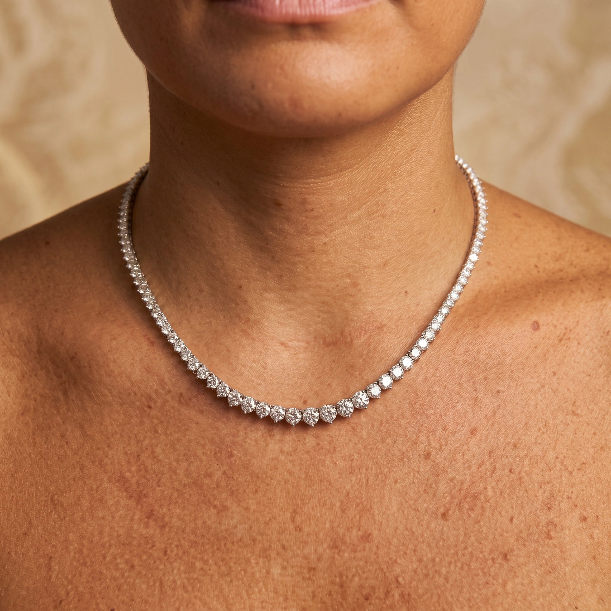 Graduated moissanite tennis necklace  worn on the neck, stones rising from the nape to the largest at the centre front