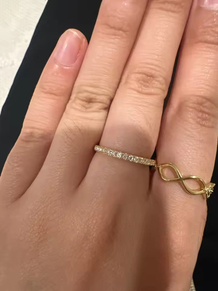 Yellow gold plated silver moissanite ring and a ring with infinity design on a hand against a neutral background - Sensitive Stones