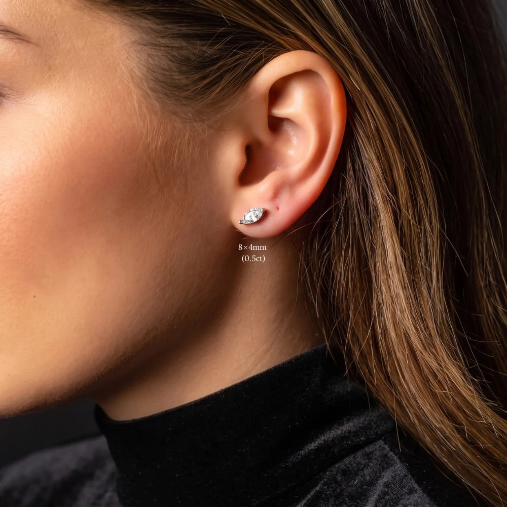 Woman wearing a single 8x4mm white gold marquise cut moissanite stud set horizontally across the lobe