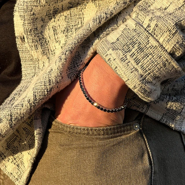 Man wearing black moissanite tennis bracelet, sterling silver setting, 18k white gold plated, natural outdoor sunlight – Sensitive Stones