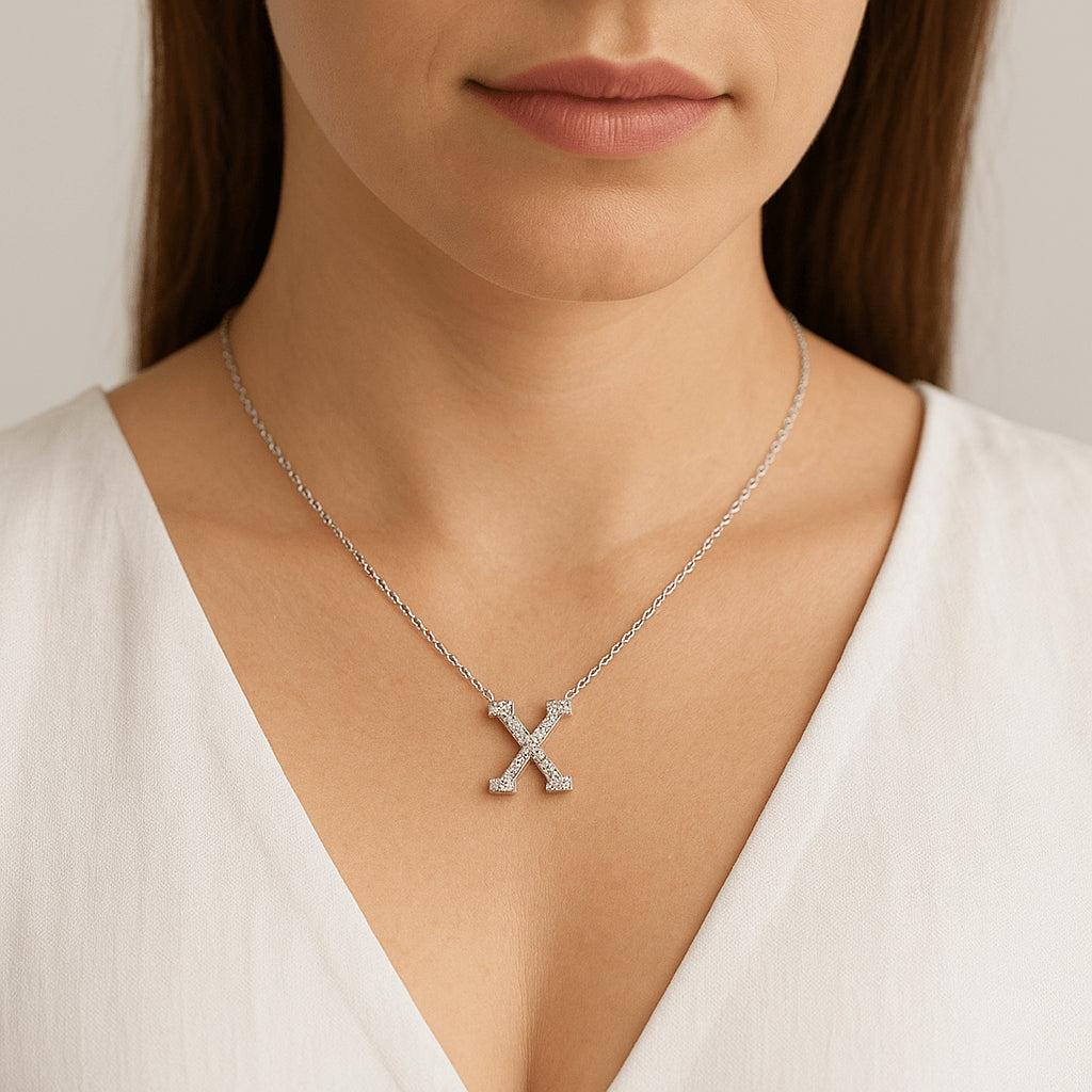 Lab-created moissanite initial ‘X’ necklace on 17.7″ 925 sterling silver chain with white gold and rhodium finish, shown on model - Sensitive Stones