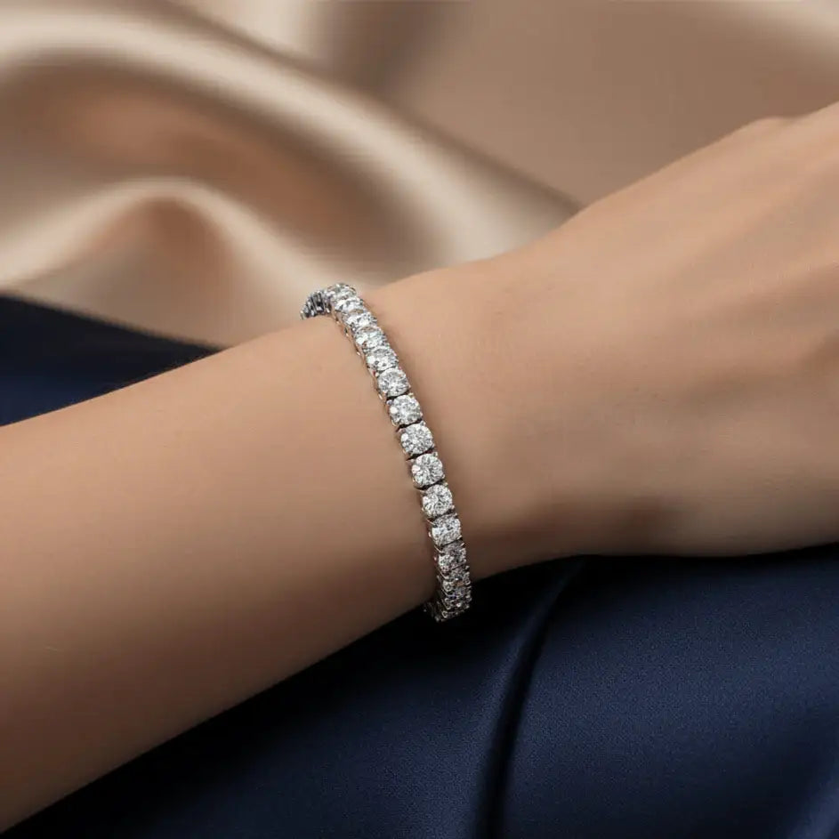 Model wearing white moissanite tennis bracelet in sterling silver with white gold plating, elegant close-up on satin background – Sensitive Stones