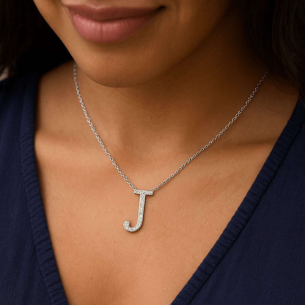 Close-up of a woman wearing a rhodium-plated 925 sterling silver moissanite initial ‘J’ pendant necklace on a delicate chain - Sensitive Stones