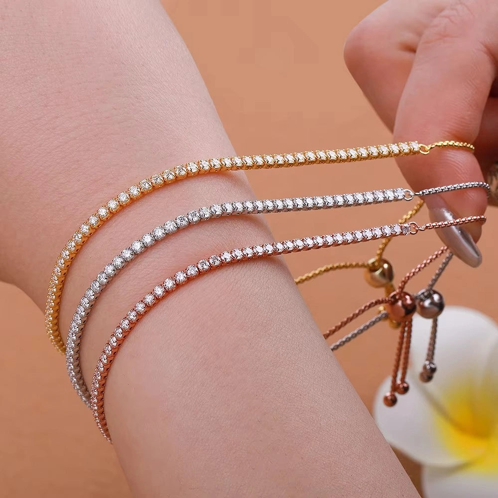 Three adjustable moissanite bolo tennis bracelets stacked on wrist displaying all 18K yellow gold, white gold, and rose gold color, each with sliding ball closure and tassel chain - Sensitive Stones