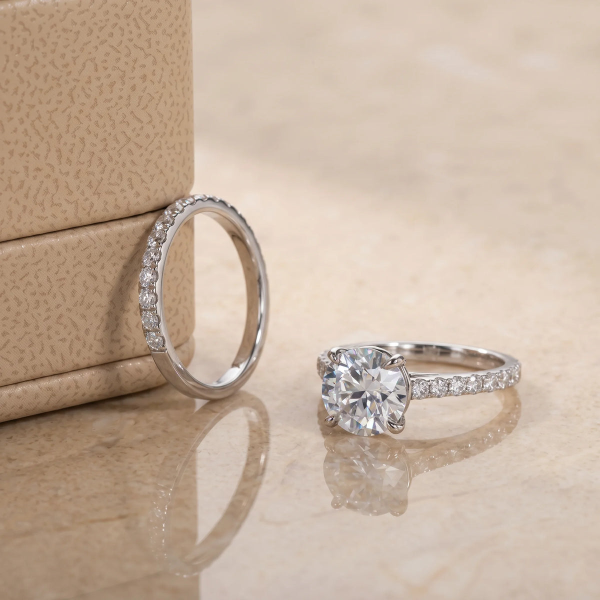 Moissanite bridal ring set shown apart with the pave wedding band upright beside the 4-prong engagement ring in 925 sterling silver - Sensitive Stones