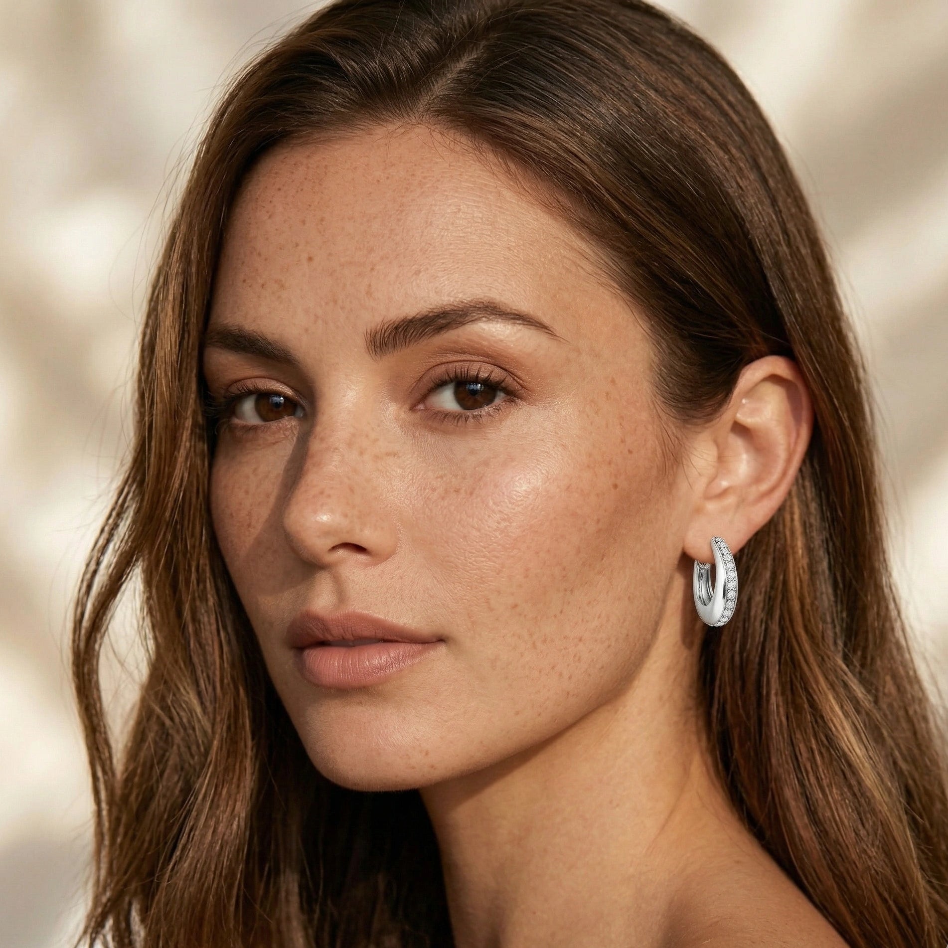 Moissanite chunky pavé hoop earrings in 925 sterling silver worn on model portrait lifestyle shot with natural light - Sensitive Stones
