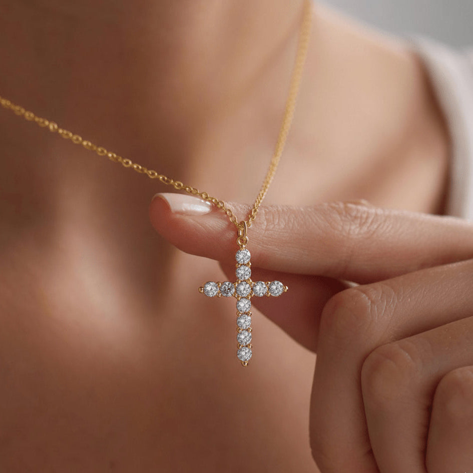 Woman holding a moissanite cross pendant in 925 sterling silver plated with 18k yellow gold - Sensitive Stones