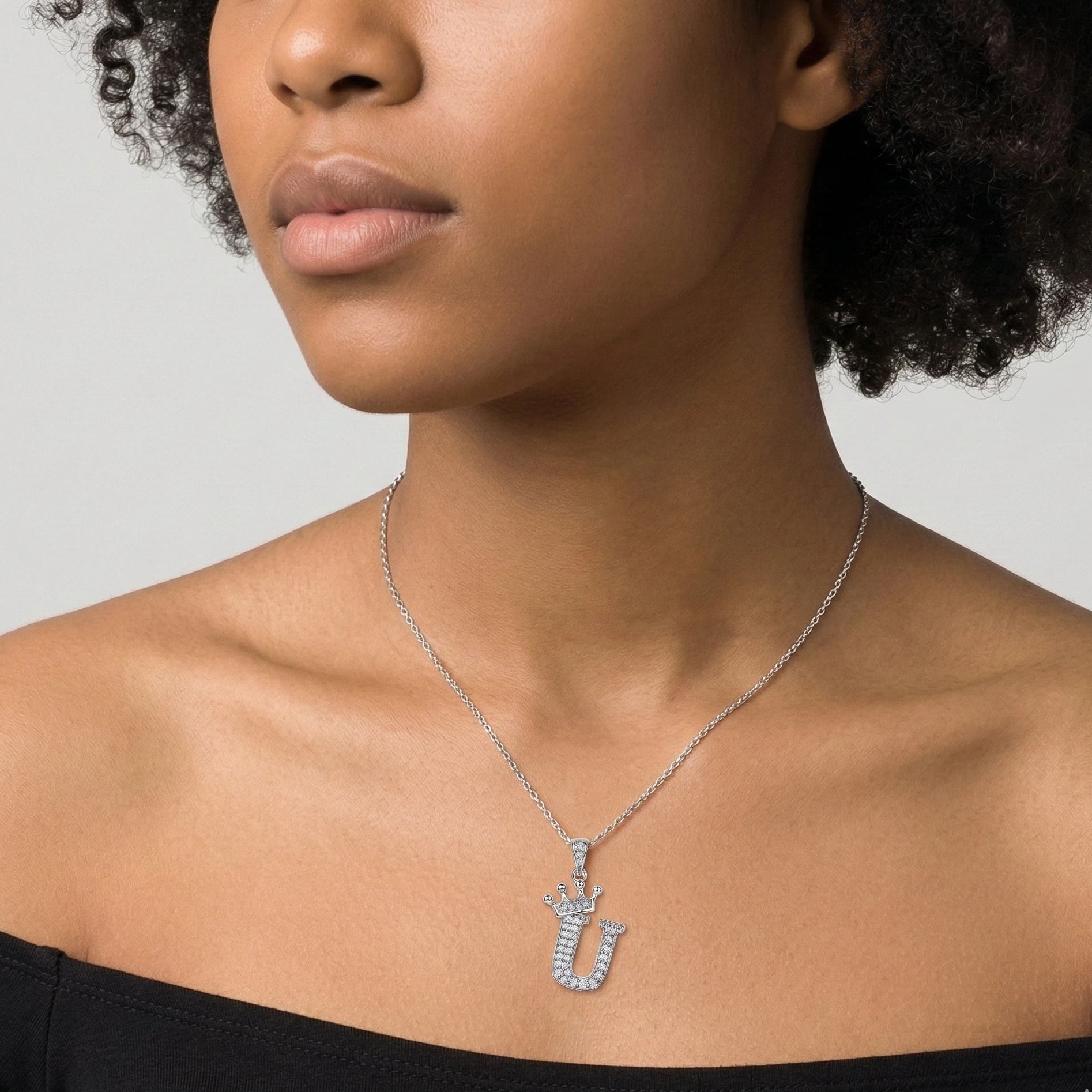 Moissanite crown initial necklace letter U worn by model at collarbone black off-shoulder top - Sensitive Stones