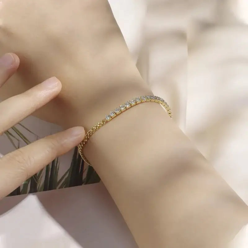 Yellow gold plated sterling silver moissanite half tennis bracelet on wrist with sunlight reflection and palm leaf background – Sensitive Stones