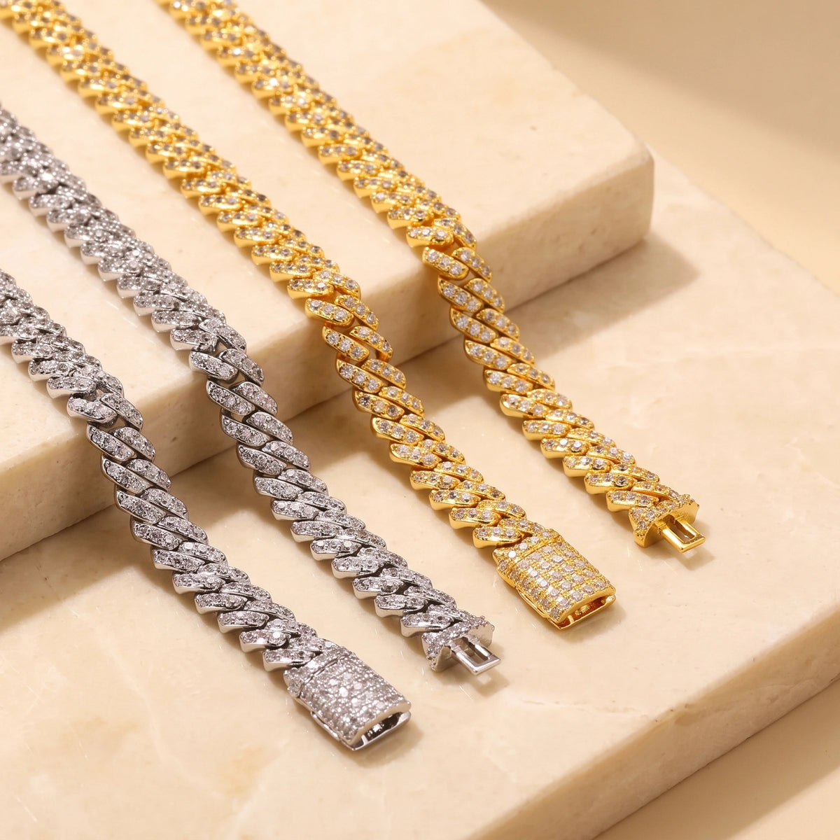 White gold and yellow gold moissanite Cuban link bracelets with the tongue-and-box clasp shown open