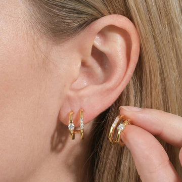 Close up of moissanite double band cuff earrings in yellow gold color on ear featuring modern architectural design with brilliant stones - Sensitive Stones